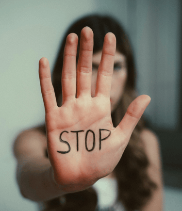 a woman holding a stop sign with the word stop written on it