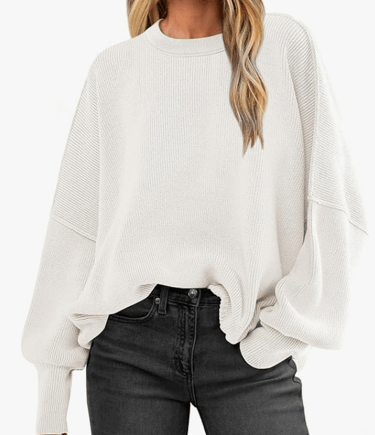 a woman wearing a white sweater and black jeans
