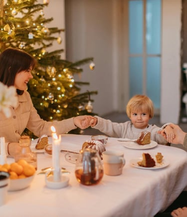 a woman and her son are sitting at a Christmas table