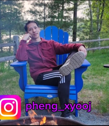 a man sitting in a blue chair on vacation with a lake background in a forest cabin