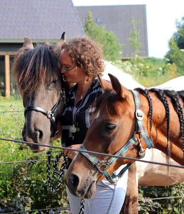Claudia met twee paarden een bruine en een bruin wit paard