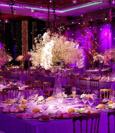 Salón decorado con luces rosas, mesas elegantes y ambiente sofisticado para eventos.