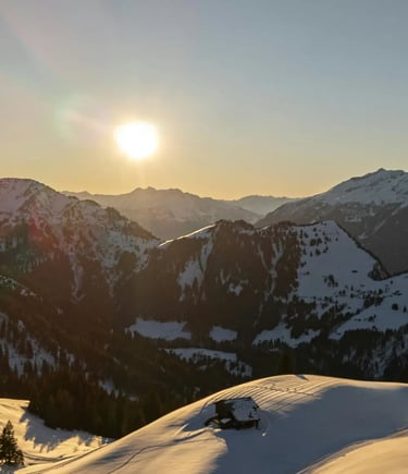 A panoramic view of sun-drenched, snow-covered mountain peaks and ski runs from a high alpine statio