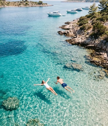 Couple floating in crystal clear turquoise Blue Lagoon near Split, aerial drone view