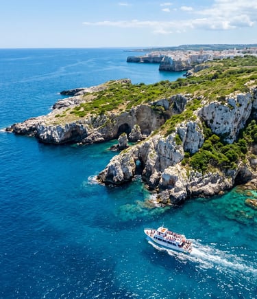 Drone shot of white limestone cliffs and tour boat sailing along Puglia coast