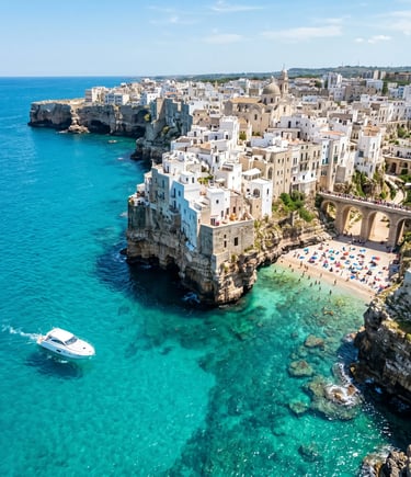 Aerial view of Polignano a Mare white cliffs turquoise sea and private boat near Lama Monachile