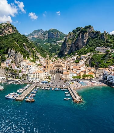 Aerial view of Amalfi cathedral and waterfront harbor with turquoise Mediterranean water