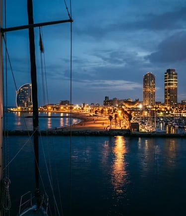 Barcelona waterfront and W Hotel at blue hour seen from a sailing yacht at sea