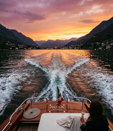 Stern view of luxury wooden boat cruising Lake Como at sunset with mountain silhouettes Italy