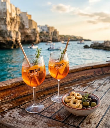 Two Aperol Spritz glasses and taralli on wooden boat deck overlooking Puglia coast