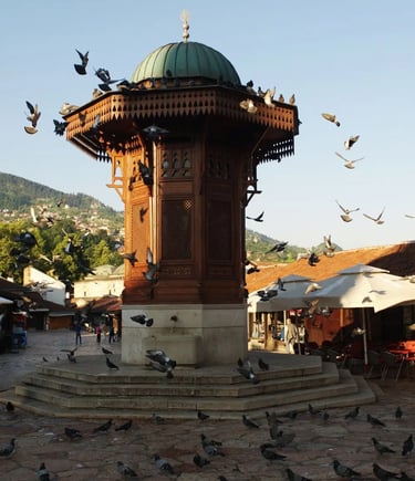 Ottoman wooden Sebilj fountain in Baščaršija square Sarajevo surrounded by flying pigeons