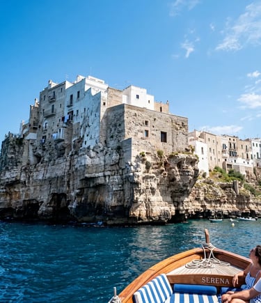 Dramatic white limestone cliffs of Polignano a Mare seen from wooden boat on blue Adriatic Sea