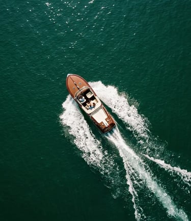 Aerial drone view of vintage mahogany boat cutting through emerald Lake Como waters