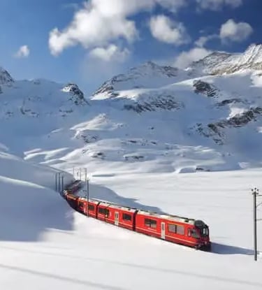 Bernina Express train winding through snowy Swiss Alps