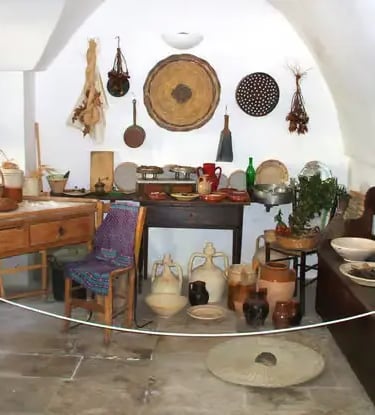 Authentic interior of traditional trullo home with rustic kitchen and artifacts in Alberobello