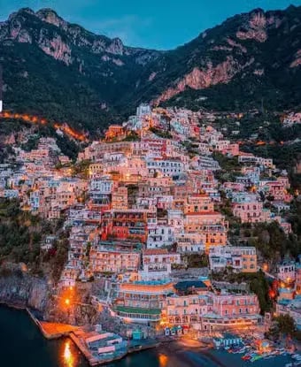 Positano colorful hillside houses illuminated at dusk seen from the sea