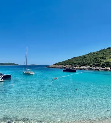 Turquoise Blue Lagoon cove at Drvenik Veli Croatia with sailboats and green hillside