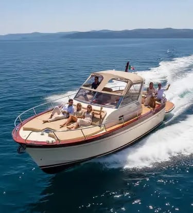 Private wooden gozzo yacht cruising the Tyrrhenian Sea with guests on deck during a Capri day tour.