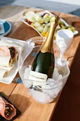 Chilled champagne bottle in ice bucket on luxury catamaran deck during private cruise in Milos