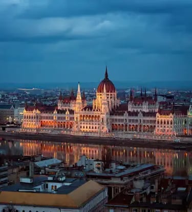 Hungarian Parliament Building illuminated at night reflecting on the Danube River in Budapest