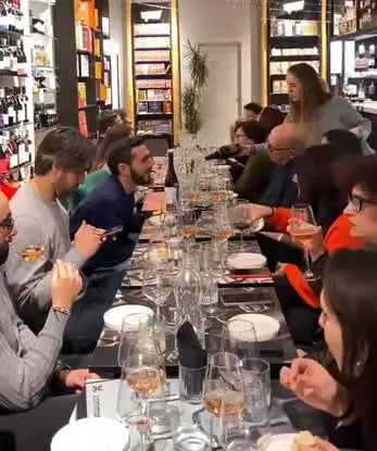 Guests seated at long table during Primitivo wine tasting event at Libreria Liberrima Bari