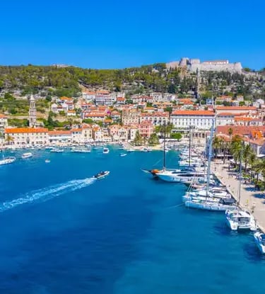 Aerial view of Hvar harbor with luxury yachts and Fortica fortress on the hilltop