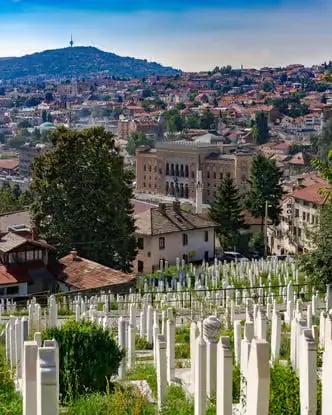Sarajevo panoramic view with Vijećnica city hall, hillside cemetery, and surrounding mountains