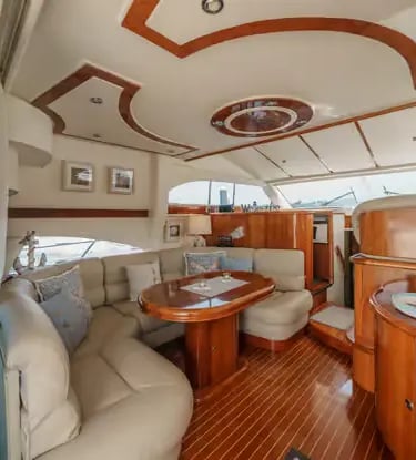 Elegant saloon interior of a Douro cruise yacht with cream sofa and mahogany wood finishes.
