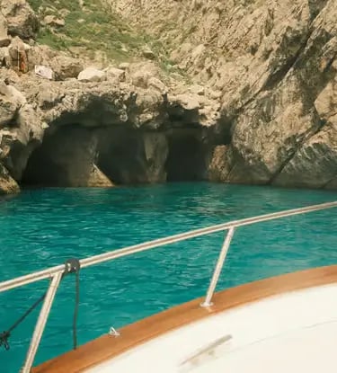View of Green Grotto turquoise water and cave entrance from the bow of a traditional Caprese gozzo.