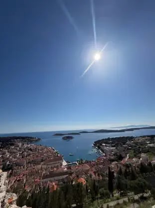 Sunlit panoramic view of Hvar town harbor and Pakleni Islands from fortress hilltop
