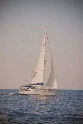 Sailboat under full sail gliding through still waters of the Sulcis Archipelago