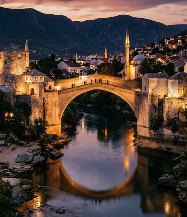 The historic Stari Most stone bridge glowing at night reflected in the Neretva River in Mostar, Bosnia