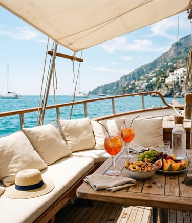 Aperol spritz cocktails, fresh fruit and snacks on wooden boat table overlooking turquoise sea