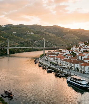 Peso da Régua waterfront at sunset with Douro river cruise boat docked and terraced vineyards