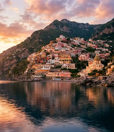 Colorful Positano village cascading down cliffs reflected in calm sea at sunset