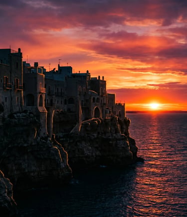 Silhouette of Polignano a Mare cliff houses against orange and purple sunset sky over Adriatic Sea