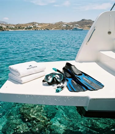 Snorkel mask fins and folded towels on a white boat swim platform over clear water