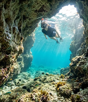 Woman snorkelling in clear turquoise water inside a Mediterranean sea cave in Salento, Puglia