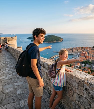 Teenage boy and young girl on Dubrovnik city walls pointing at Adriatic Sea and old town below