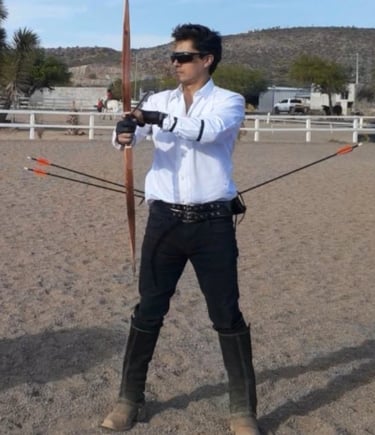 a man in a white shirt and black pants holding a bow and arrows. ambidextrous archery