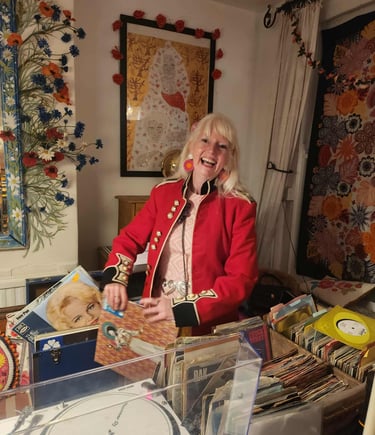 DJ Charlotte Hypno Bird playing records at a 60th birthday party wearing 60s vintage dress