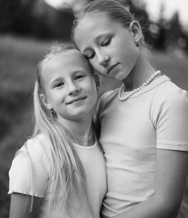 Two girls sisters hugging each other in black and white image