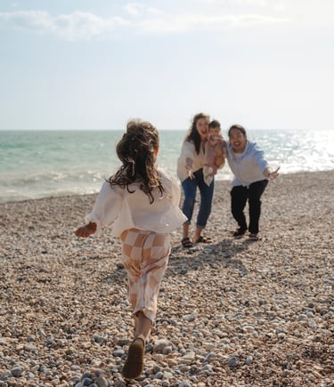 Little girl running towards her parents on Brighton beach