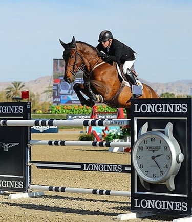 Rider Will Simpson jumping a large vertical on a large bay horse