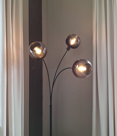 Zoom sur un luminaire sur pied avec trois globes lumineux en verre