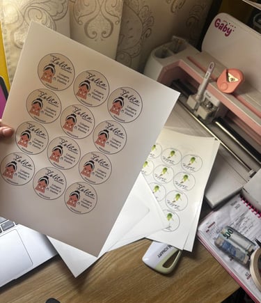 Custom printed cosmetic labels for skincare products displayed on a craft desk with a Cricut machine.