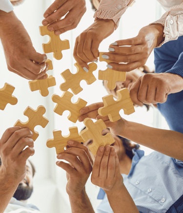 a group of people holding puzzle pieces