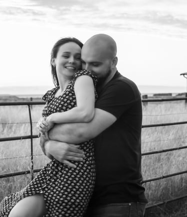 a man and woman are standing in front of a fence
