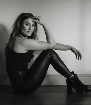 a woman in black and white photo of a woman in leather pants and boots
