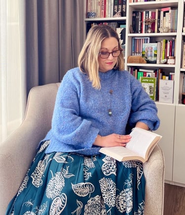 Julie Mitrovic sitting reading a book, Positive Psychology & embodiment coach